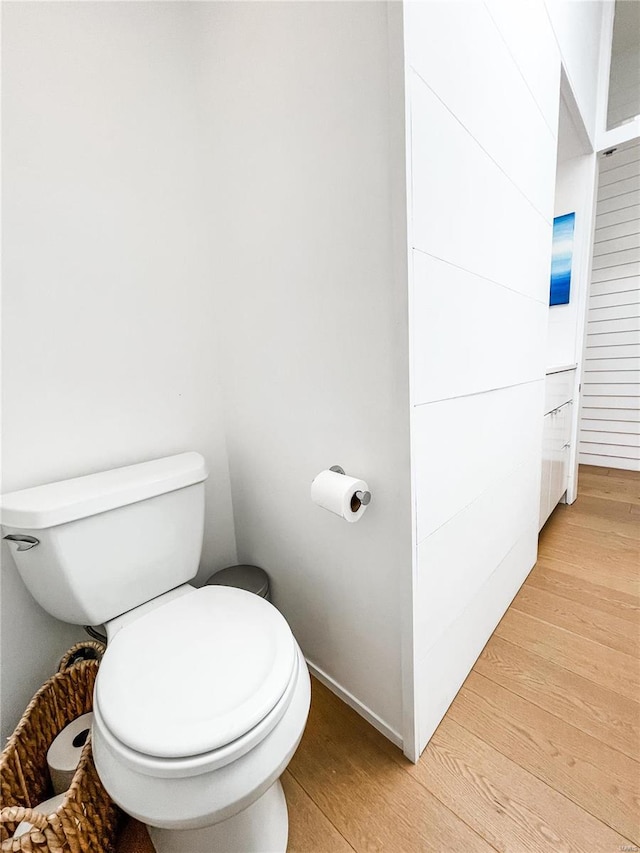 bathroom with hardwood / wood-style flooring and toilet