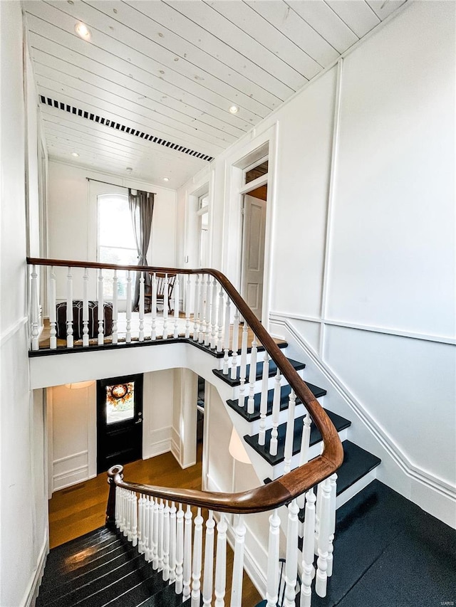 stairway with hardwood / wood-style flooring and wooden ceiling