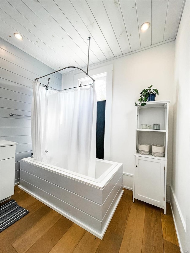 bathroom with hardwood / wood-style flooring, vanity, and shower / bath combination with curtain