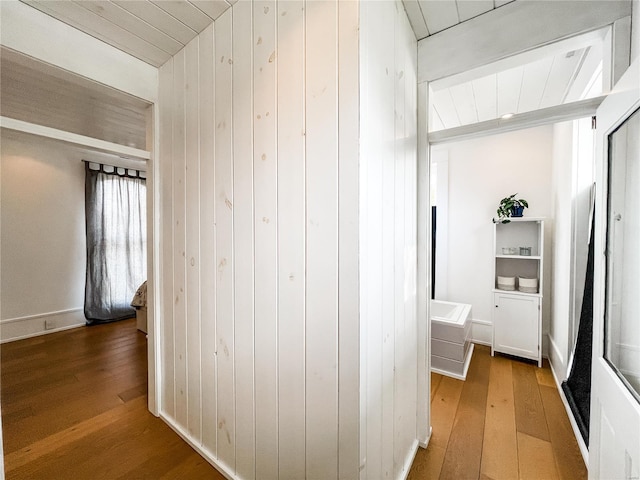 corridor featuring wooden walls and hardwood / wood-style floors