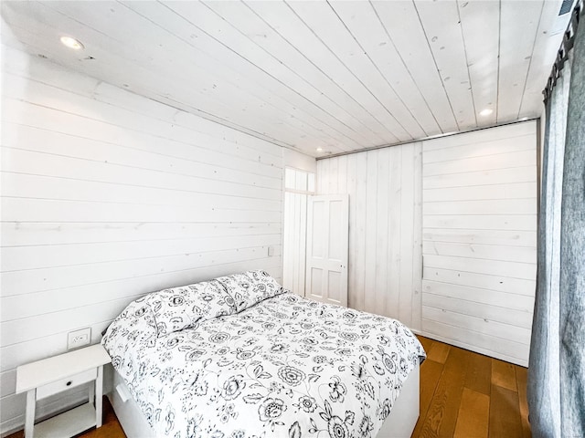 bedroom with hardwood / wood-style floors, wood walls, and wood ceiling