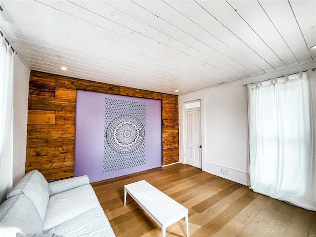 living room with light hardwood / wood-style flooring and wood walls