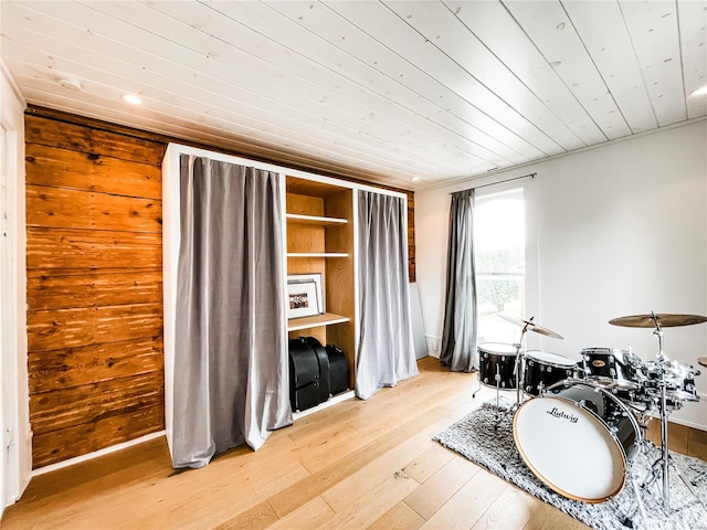 interior space featuring wood walls, light wood-type flooring, and wooden ceiling