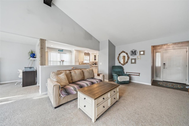 living area with light carpet, high vaulted ceiling, and baseboards