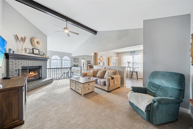 living room with beamed ceiling, light colored carpet, a fireplace, high vaulted ceiling, and a ceiling fan