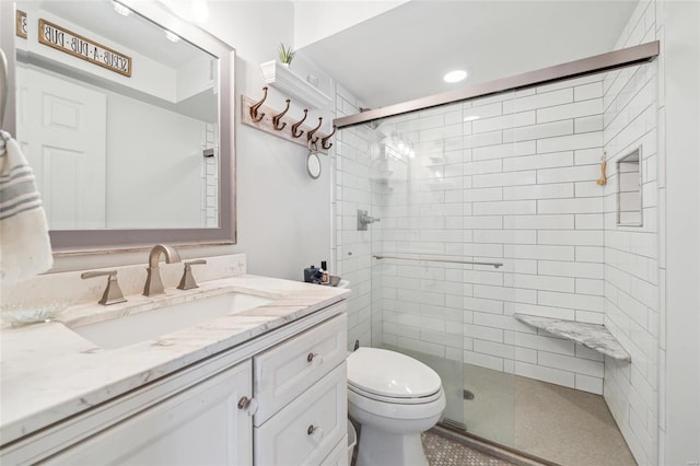 full bathroom featuring a shower stall, toilet, and vanity