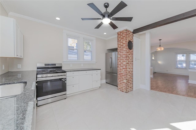 kitchen with white cabinetry, stainless steel appliances, dark stone counters, and a healthy amount of sunlight