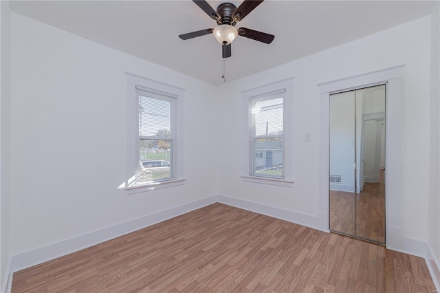 unfurnished bedroom featuring ceiling fan, a closet, and light hardwood / wood-style flooring