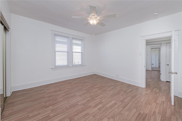 unfurnished bedroom featuring ceiling fan, a closet, and light wood-type flooring