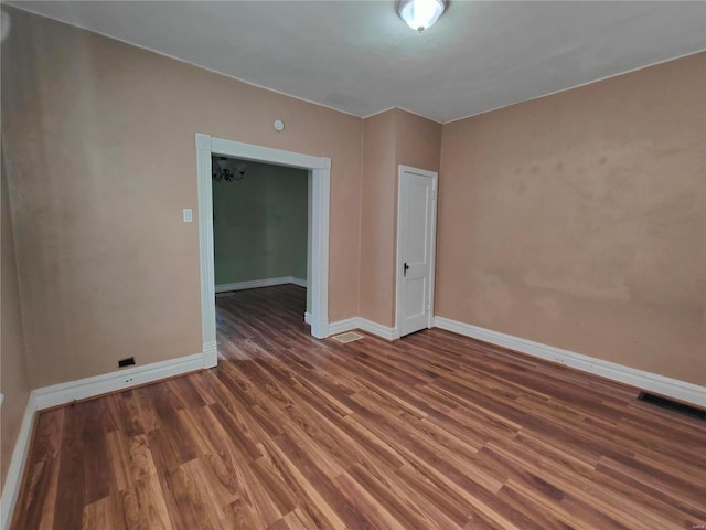 unfurnished room with dark wood-type flooring