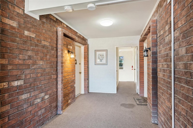 corridor with light colored carpet and brick wall