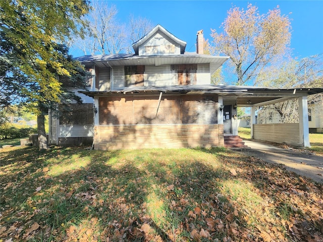 view of front of house with a front lawn and a carport