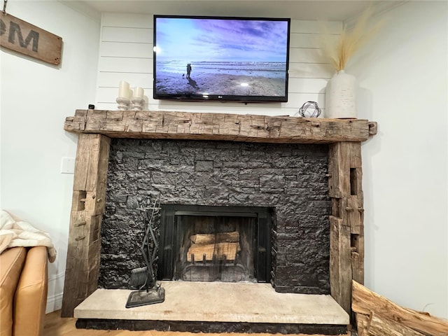 details with a stone fireplace and hardwood / wood-style floors