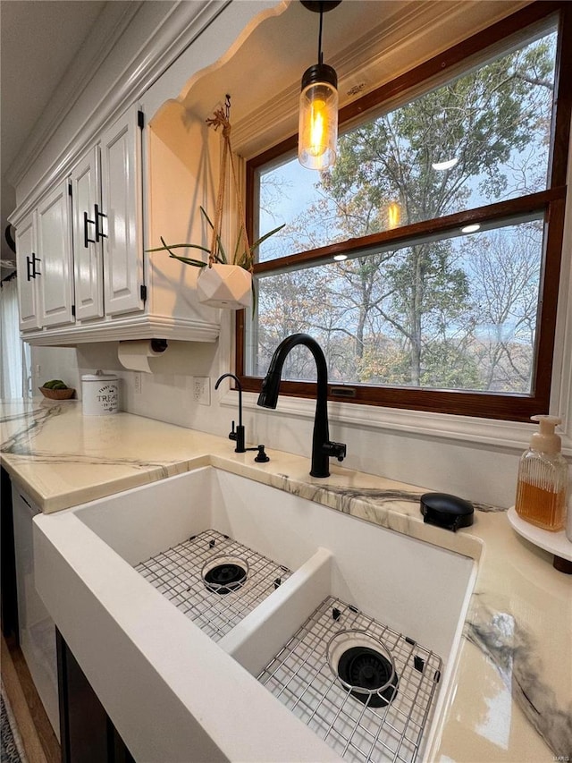 room details featuring decorative light fixtures, white cabinetry, and sink