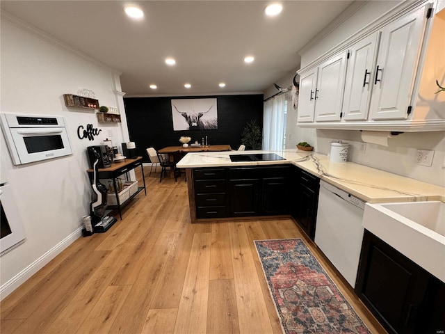 kitchen featuring kitchen peninsula, light hardwood / wood-style floors, white appliances, white cabinets, and ornamental molding