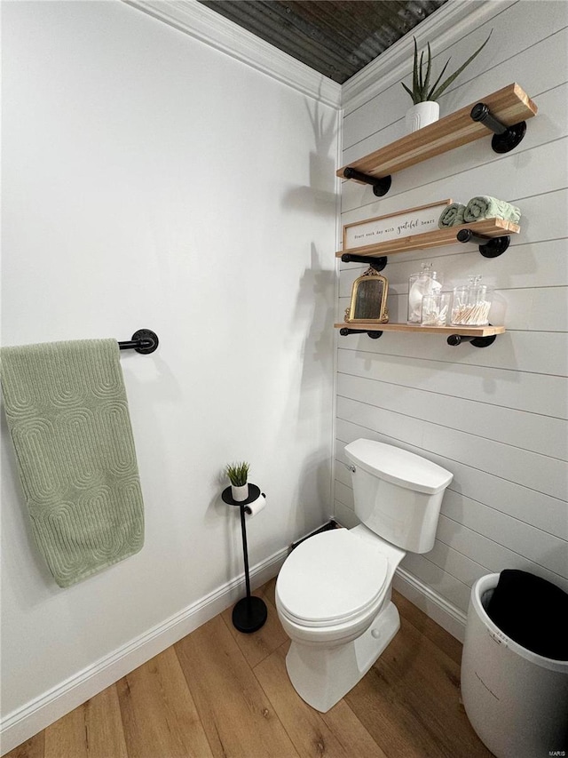 bathroom with hardwood / wood-style floors, toilet, and ornamental molding