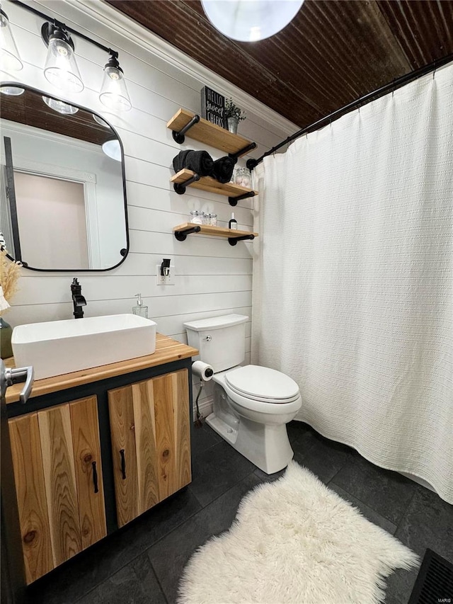 bathroom featuring wooden ceiling, tile patterned flooring, toilet, wooden walls, and vanity