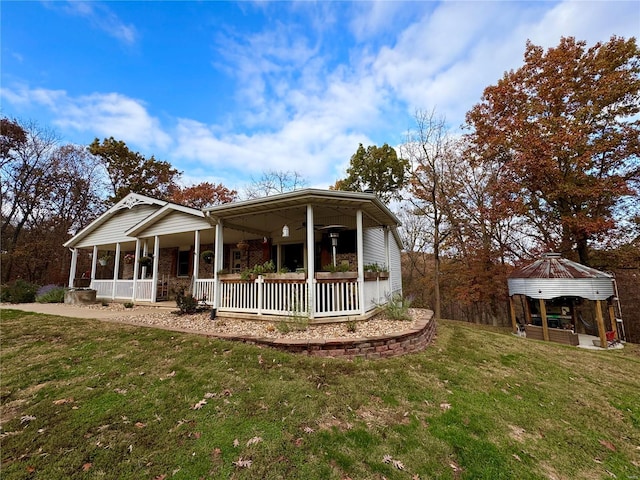 view of front of house with a gazebo, ceiling fan, a porch, and a front lawn