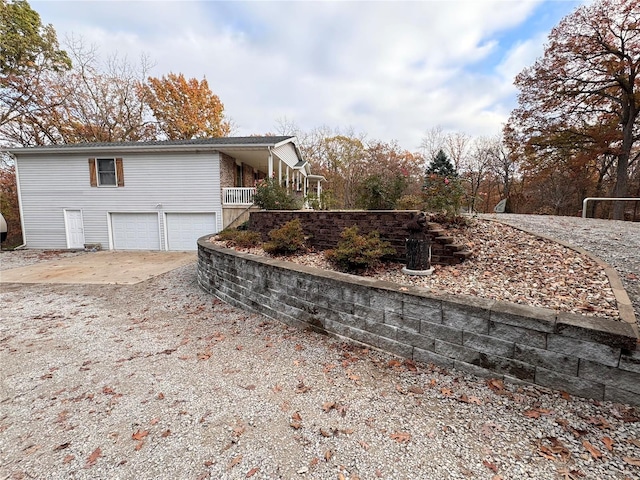 view of property exterior featuring a porch and a garage