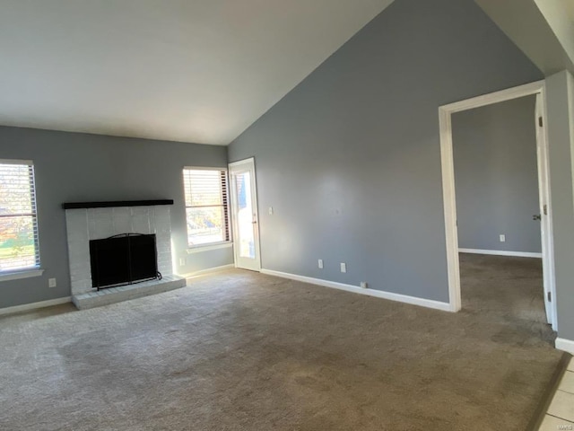 unfurnished living room with carpet floors, plenty of natural light, high vaulted ceiling, and a brick fireplace