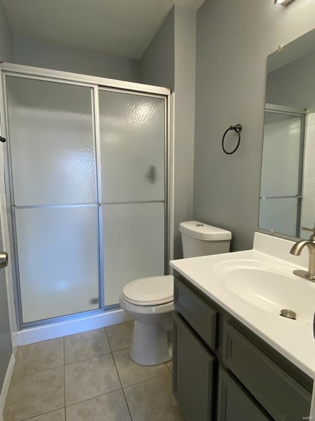 bathroom featuring tile patterned flooring, vanity, toilet, and an enclosed shower