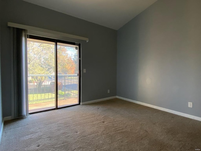 carpeted empty room with vaulted ceiling