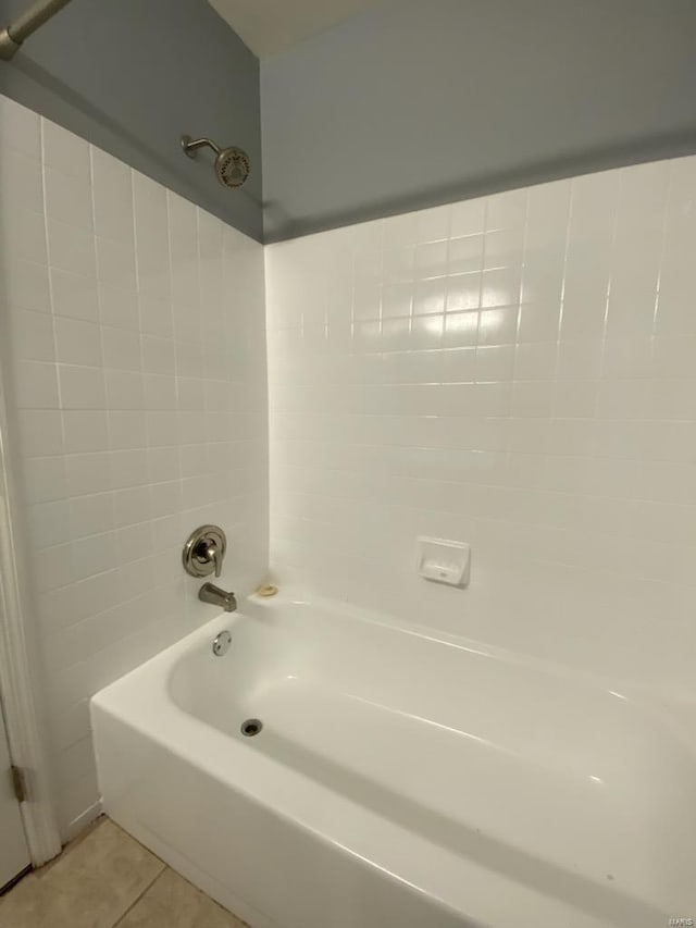 bathroom with tile patterned floors and shower / washtub combination