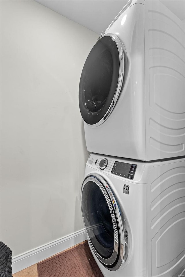 clothes washing area featuring stacked washer and dryer