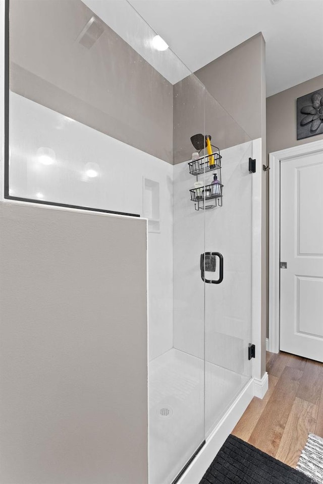 bathroom featuring a shower with door and wood-type flooring