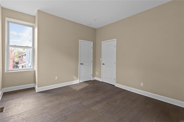 empty room with dark hardwood / wood-style flooring