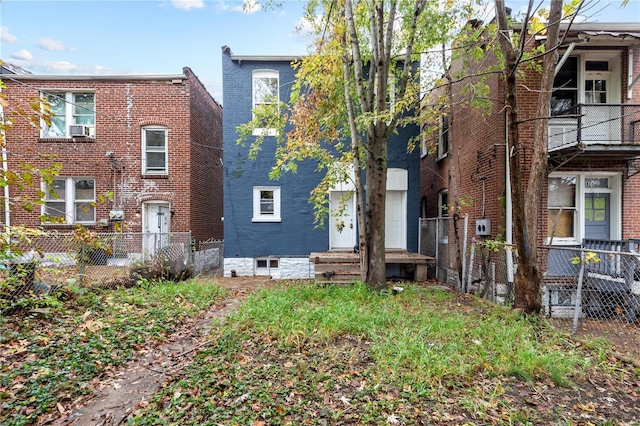 back of property with cooling unit and a balcony