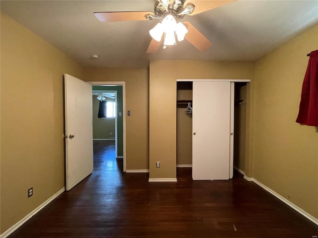 unfurnished bedroom with dark wood-type flooring, ceiling fan, and a closet