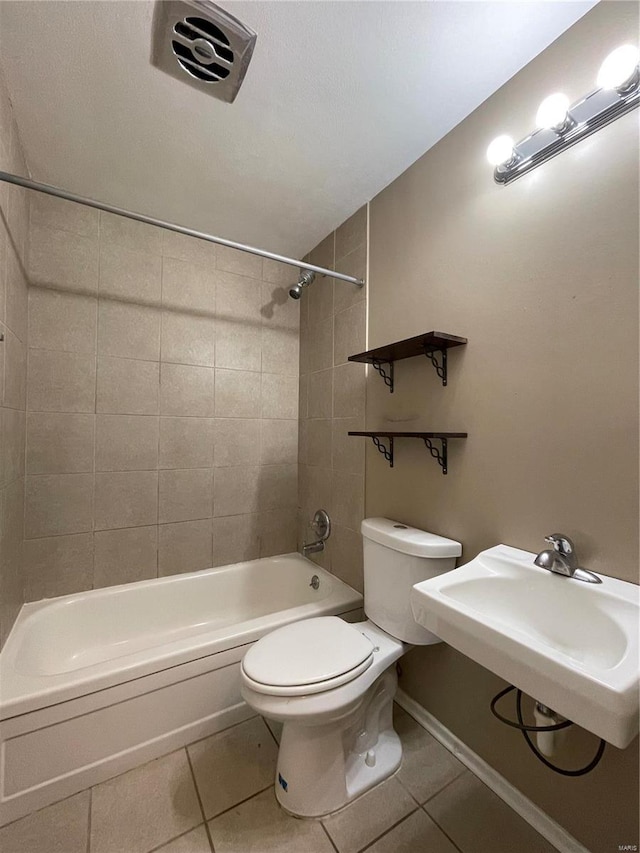 full bathroom with tile patterned floors, tiled shower / bath combo, toilet, and sink