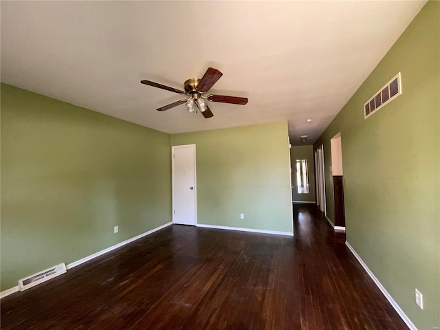 spare room with dark wood-type flooring and ceiling fan