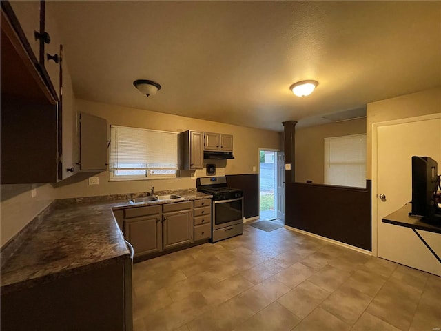 kitchen with decorative columns, a wealth of natural light, sink, and stainless steel range oven