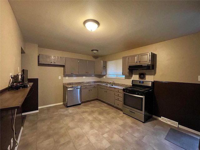 kitchen with gray cabinets, a textured ceiling, sink, and appliances with stainless steel finishes