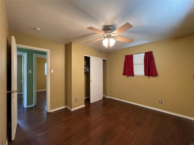 unfurnished bedroom with dark wood-type flooring, ceiling fan, and a closet