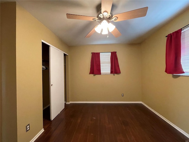 unfurnished bedroom with dark wood-type flooring, ceiling fan, and a closet