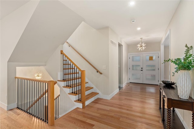 entrance foyer with an inviting chandelier and light hardwood / wood-style flooring