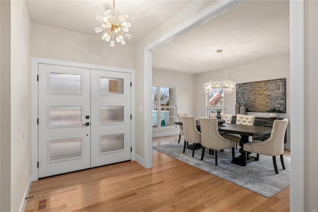 entrance foyer with light wood-type flooring and a notable chandelier