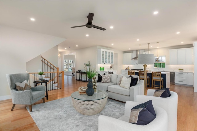 living room featuring ceiling fan, sink, and light hardwood / wood-style floors