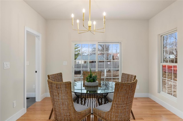 dining room featuring a notable chandelier, light hardwood / wood-style flooring, and a wealth of natural light