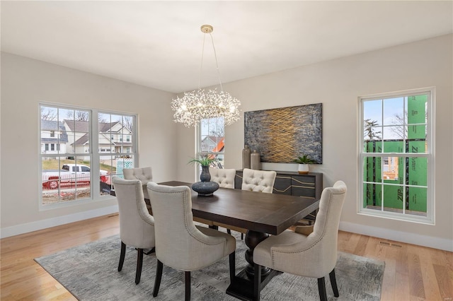 dining area with a chandelier and light hardwood / wood-style flooring