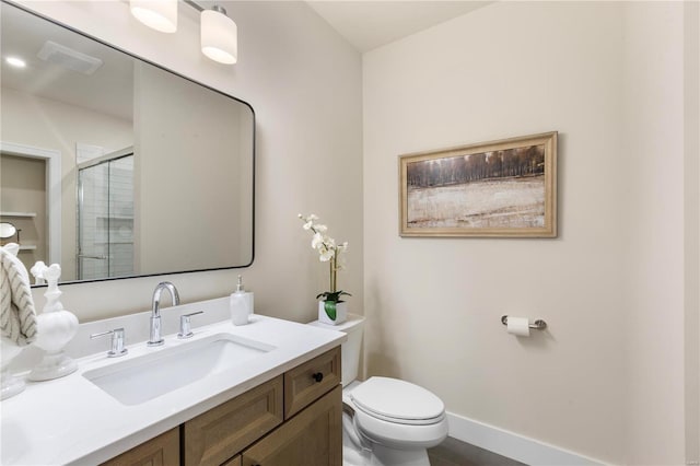 bathroom with vanity, a shower with shower door, and toilet