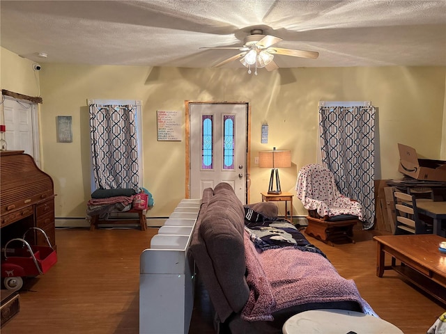 living room with hardwood / wood-style floors, a textured ceiling, and ceiling fan