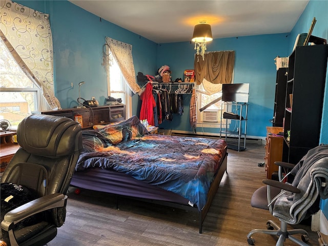 bedroom featuring a baseboard radiator, dark wood-type flooring, and cooling unit