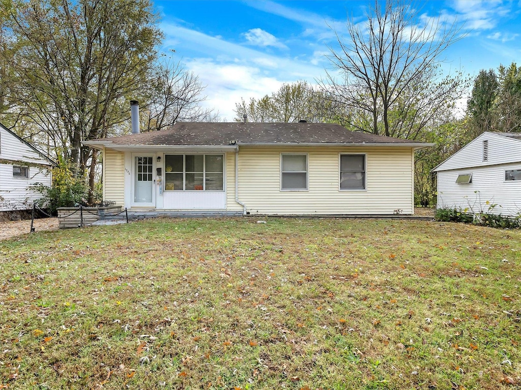 back of property with a patio and a yard