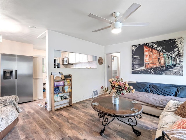 living room with wood-type flooring and ceiling fan