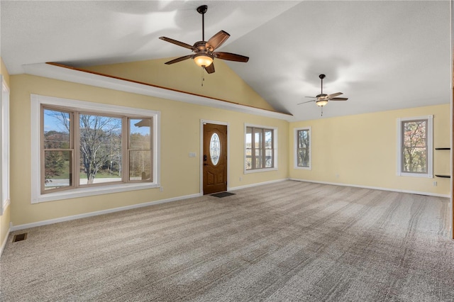 unfurnished living room with carpet flooring, vaulted ceiling, plenty of natural light, and ceiling fan