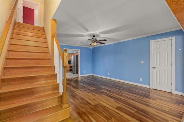 staircase with ceiling fan, wood-type flooring, and crown molding